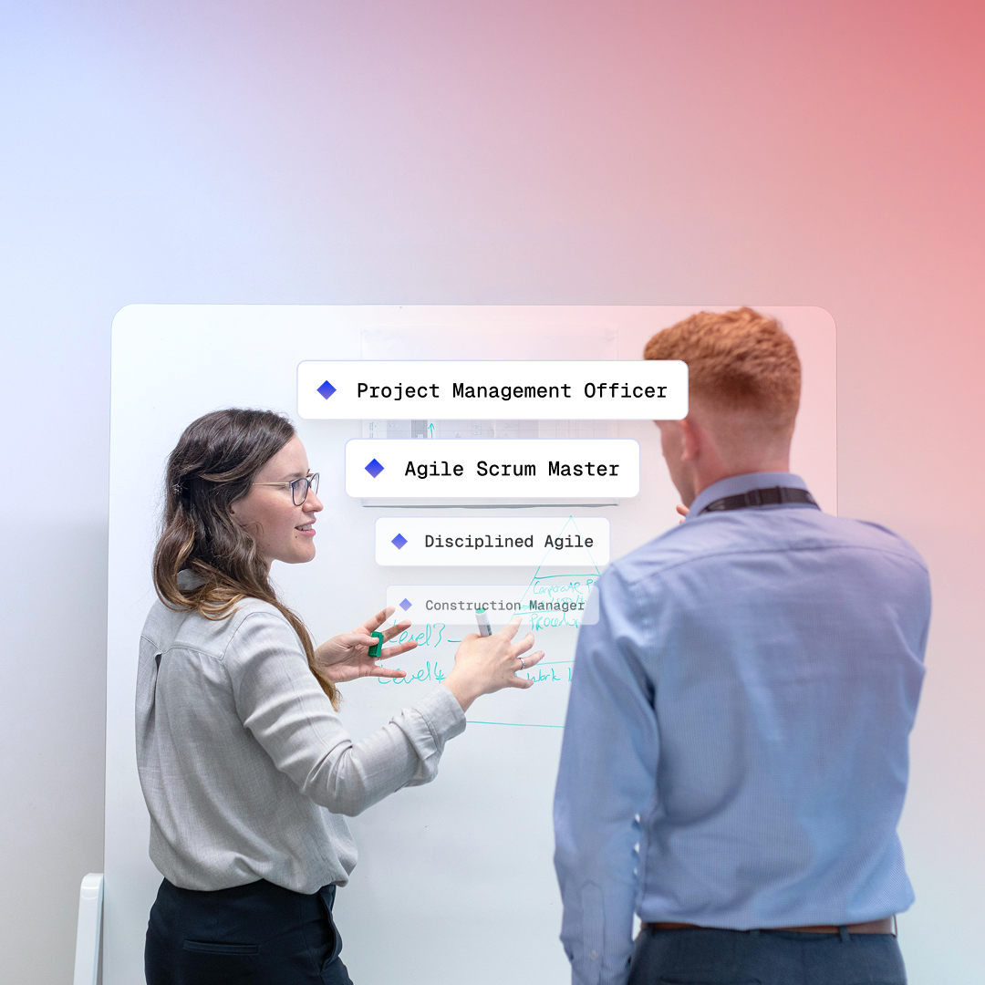 Project management consultants planning transformation on a whiteboard with sticky notes
